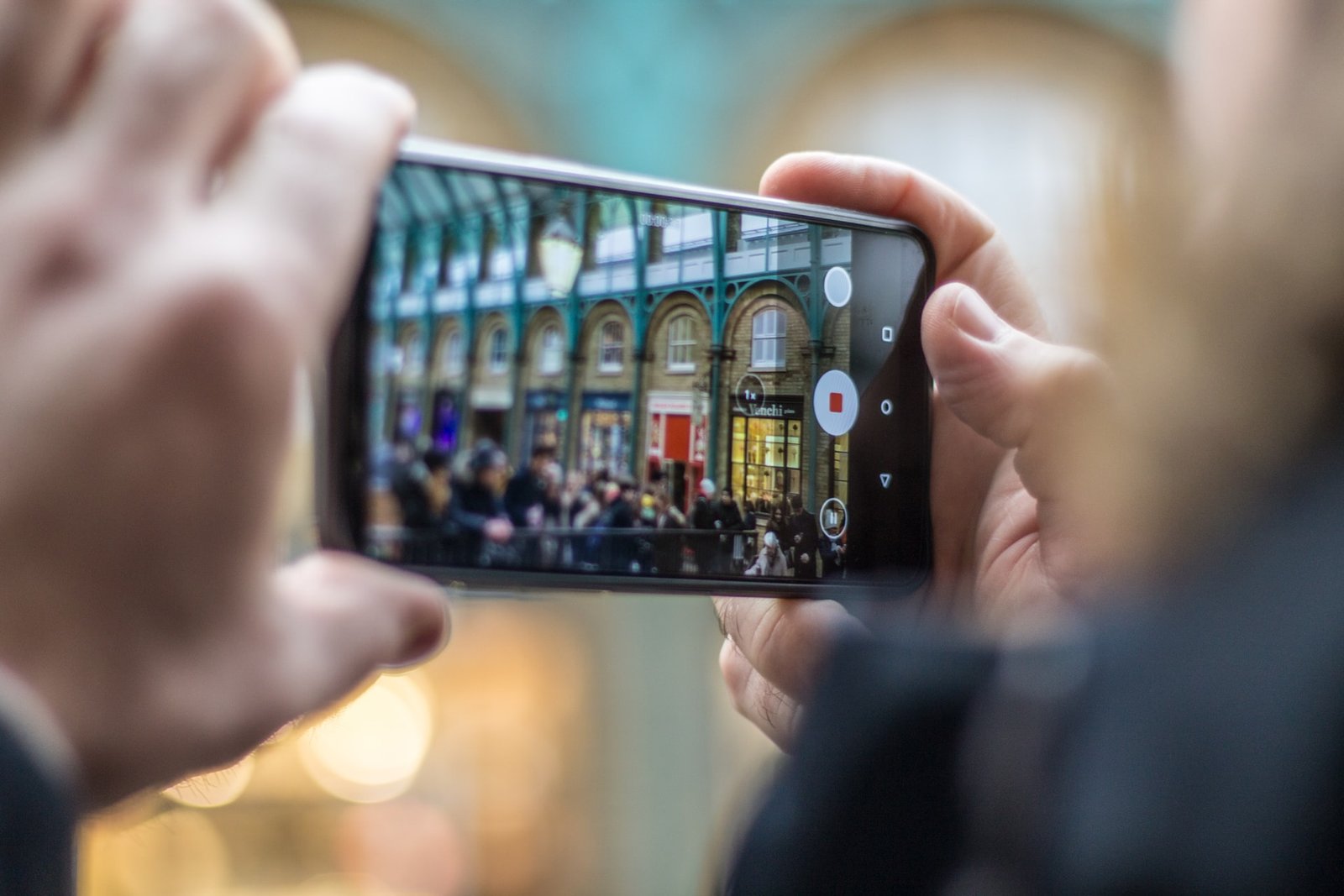 two hands holding a cell phone and recording a video